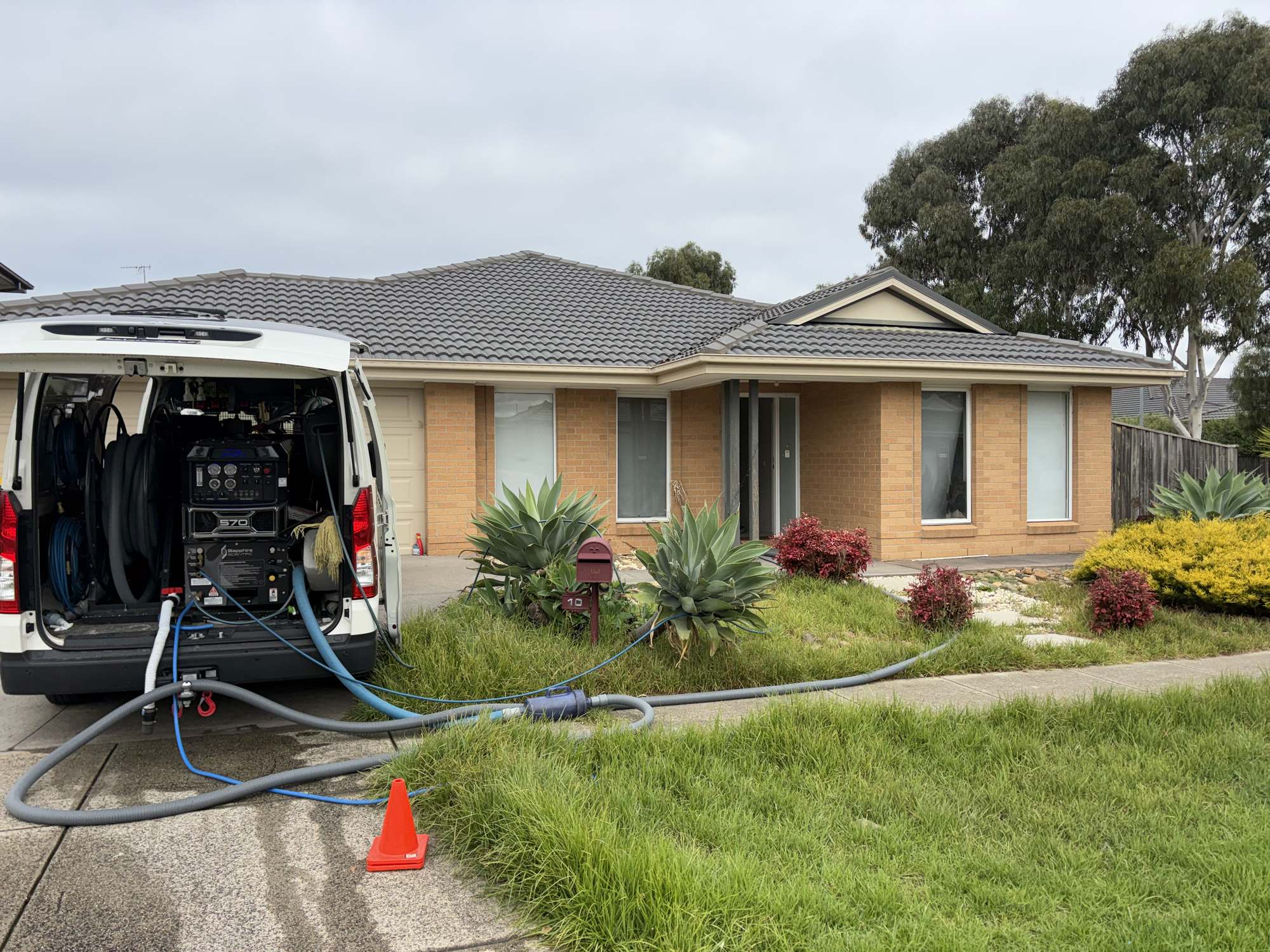 Carpet cleaning van with hoses running to a brick home in Melbourne’s west